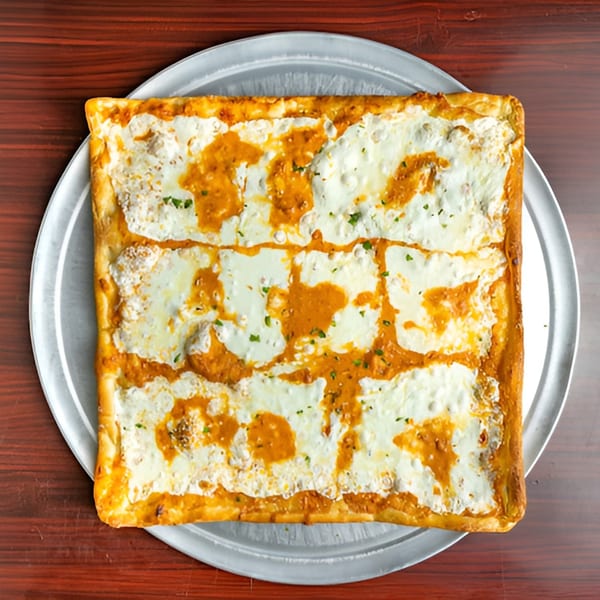 Big Joe's Pizzeria's square Sicilian pizza with white cheese and orange sauce on a metal tray.